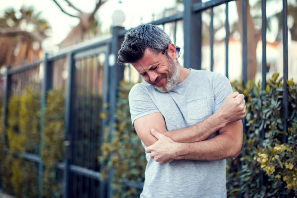 Mature man holding elbow in pain