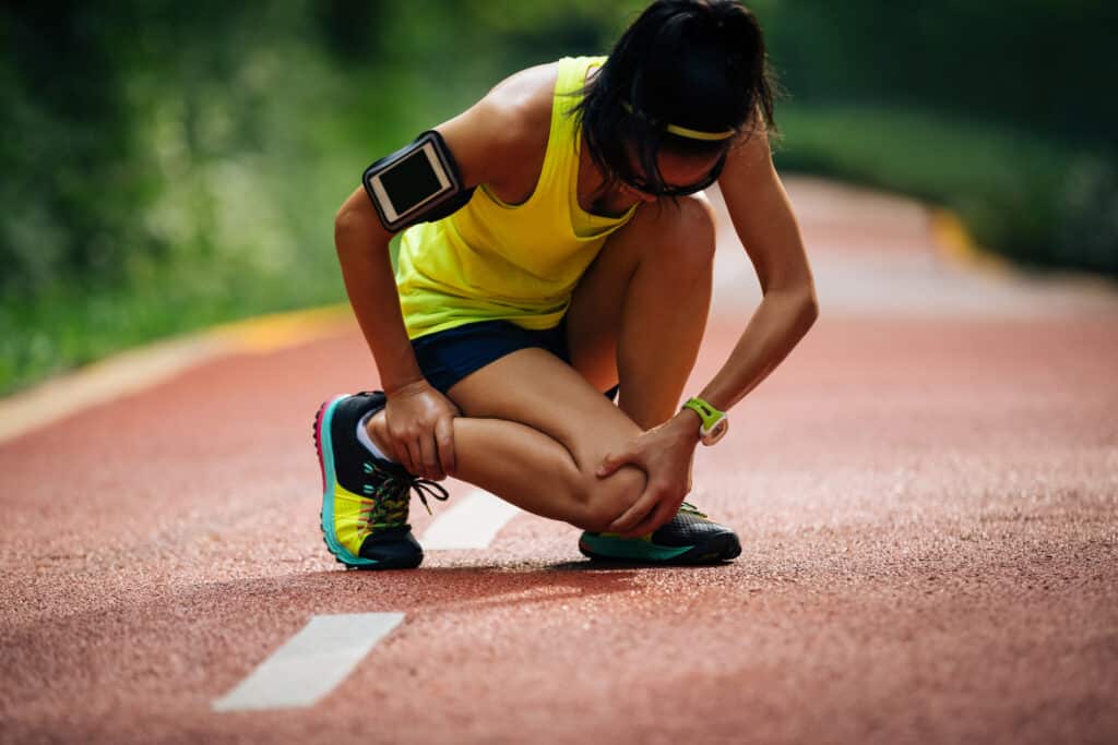 Female runner suffering with knee pain and injury