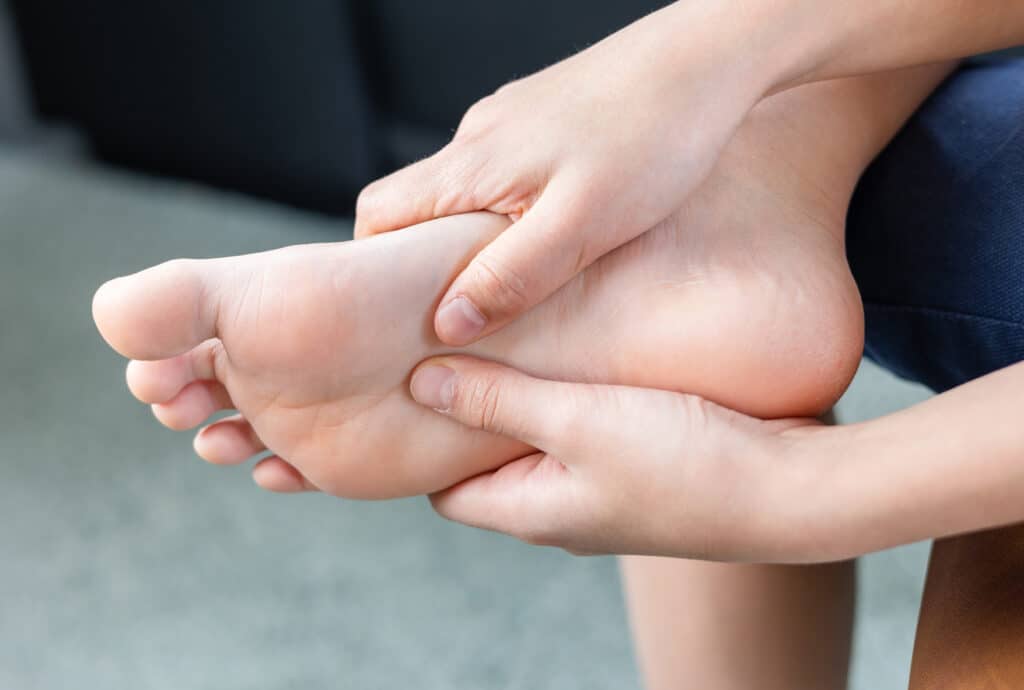 A person holding forefoot with pain