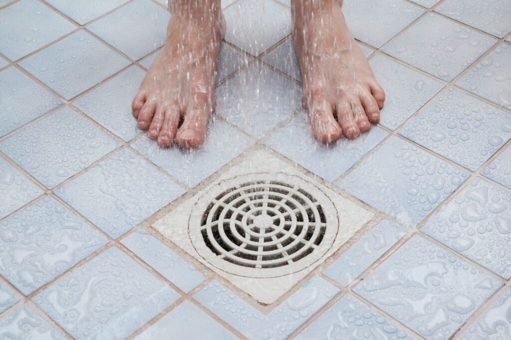 feet near drain in the shower
