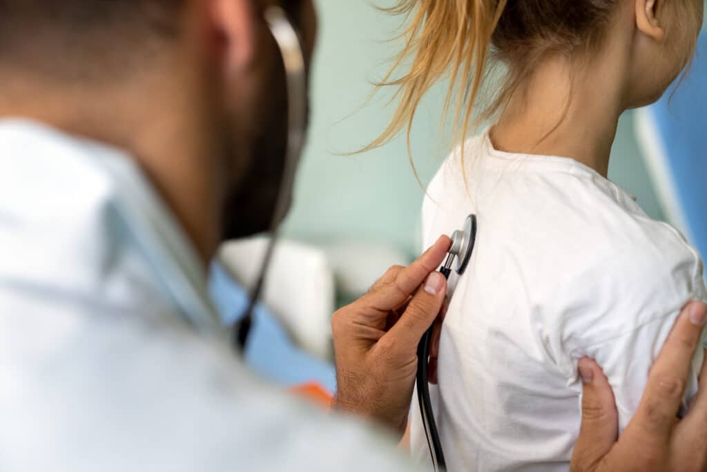 doctor listening to patients lungs with stethoscope